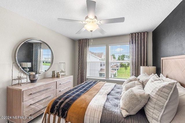 bedroom featuring ceiling fan and a textured ceiling