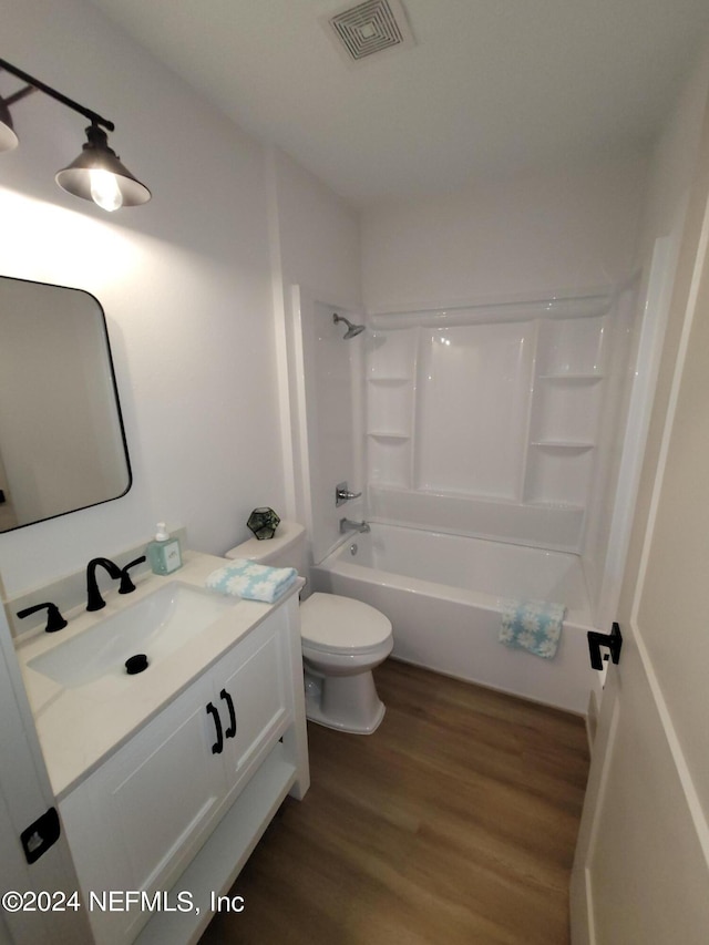 full bathroom with toilet, vanity, wood-type flooring, and shower / washtub combination