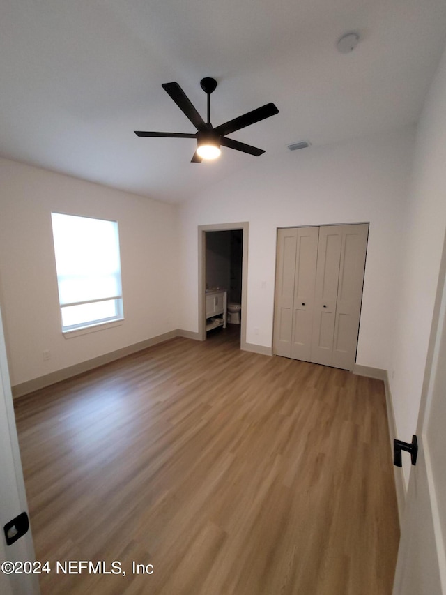 unfurnished bedroom with light hardwood / wood-style flooring, lofted ceiling, and ceiling fan