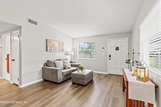 living area featuring light wood-style floors, visible vents, and baseboards