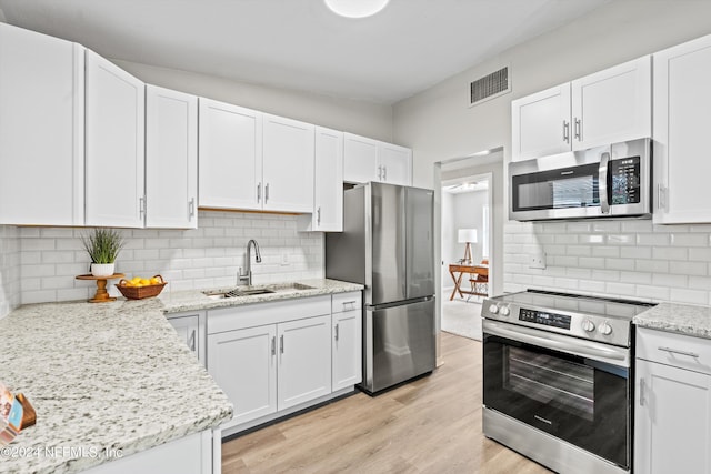 kitchen featuring stainless steel appliances, visible vents, a sink, and white cabinetry