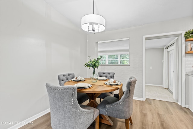 dining space with light wood-type flooring and baseboards