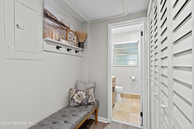 mudroom with electric panel, baseboards, and wood finished floors