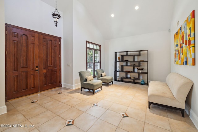 entryway with light tile patterned floors and high vaulted ceiling