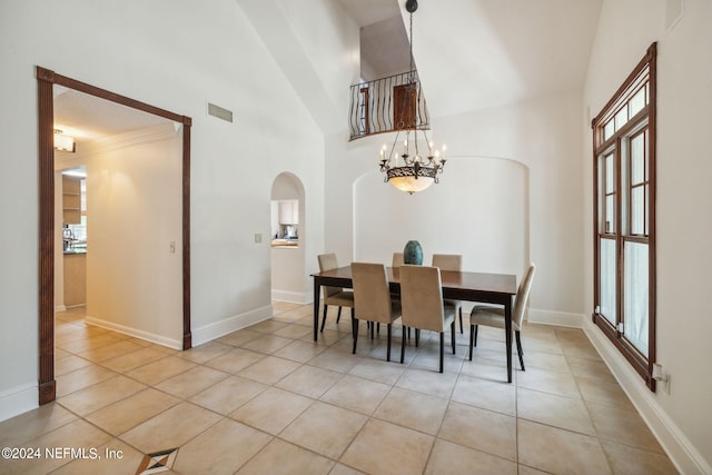 tiled dining room featuring a high ceiling and an inviting chandelier