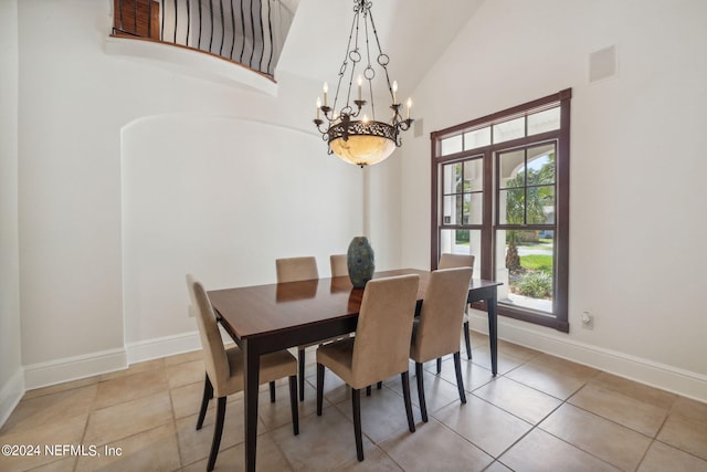 tiled dining room featuring high vaulted ceiling and an inviting chandelier