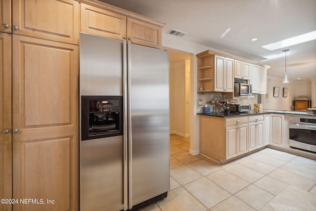 kitchen featuring light tile patterned flooring, appliances with stainless steel finishes, pendant lighting, light brown cabinetry, and a skylight