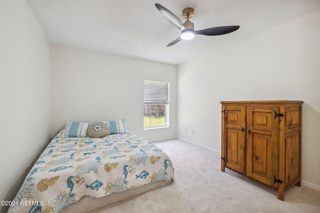 bedroom with light carpet, ceiling fan, and a textured ceiling