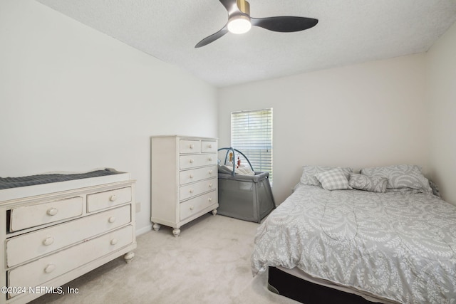 carpeted bedroom with ceiling fan and a textured ceiling