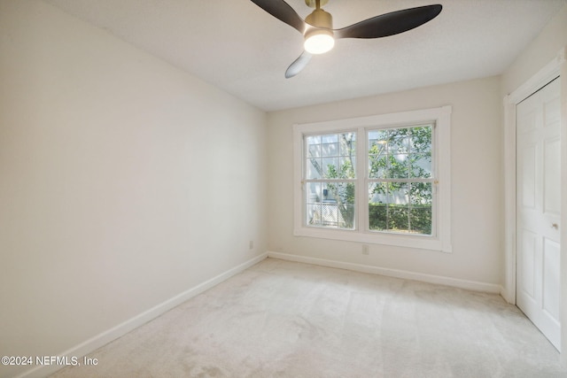 unfurnished bedroom featuring light colored carpet and ceiling fan