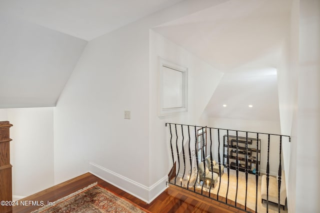 hallway featuring vaulted ceiling and hardwood / wood-style floors