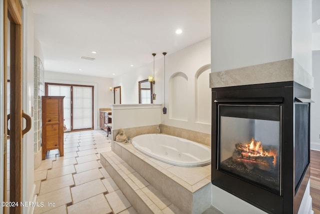 bathroom featuring tiled bath and tile patterned floors