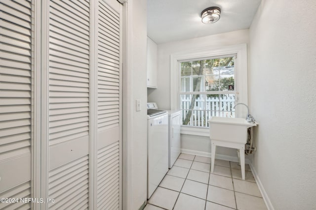 laundry room featuring cabinets, light tile patterned flooring, and independent washer and dryer