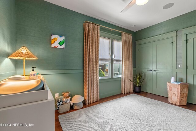 unfurnished bedroom with ceiling fan, a closet, and hardwood / wood-style flooring