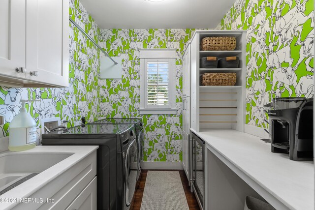 clothes washing area featuring cabinets, washing machine and dryer, sink, and dark hardwood / wood-style floors