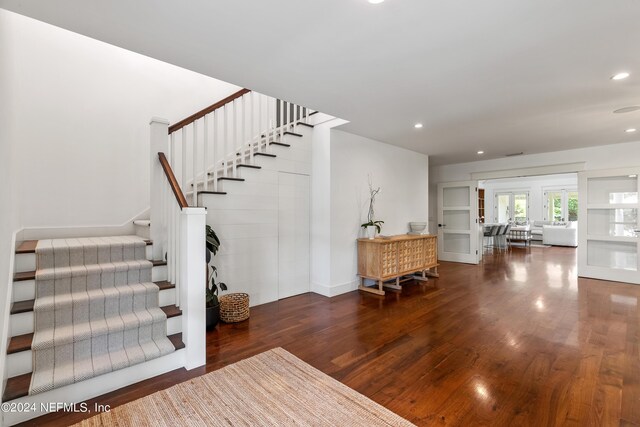 stairway with wood-type flooring and a fireplace