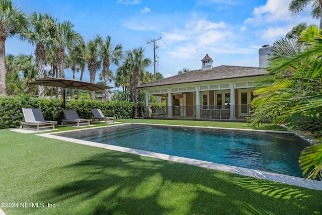 view of pool featuring a patio, a yard, french doors, and a fenced in pool