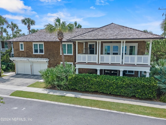 view of front of house with a balcony, a garage, and driveway