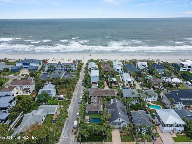 drone / aerial view featuring a beach view and a water view