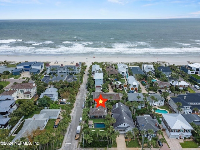 drone / aerial view featuring a water view and a beach view