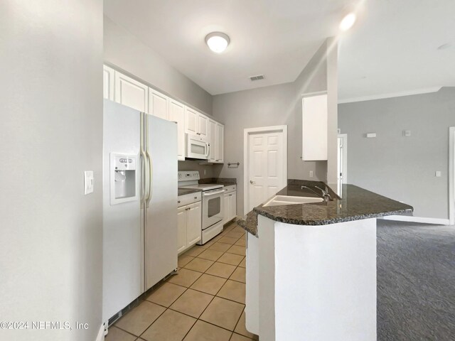 kitchen featuring white appliances, light carpet, white cabinetry, sink, and kitchen peninsula