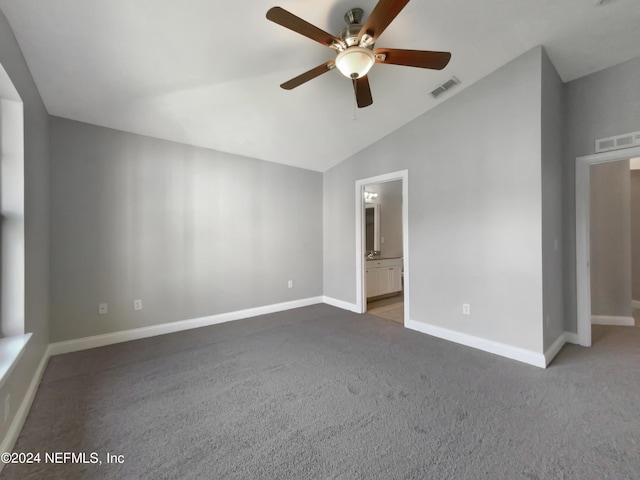 unfurnished bedroom featuring lofted ceiling, ensuite bathroom, ceiling fan, and carpet flooring