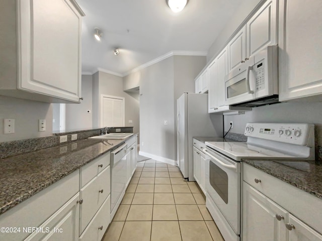 kitchen featuring sink, white appliances, white cabinetry, ornamental molding, and dark stone counters