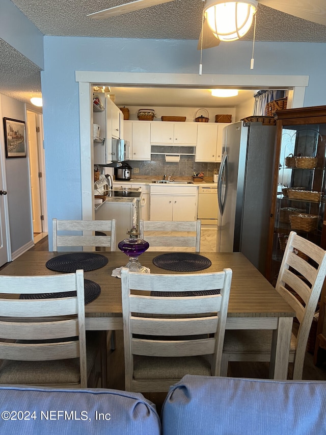 dining room featuring sink and a textured ceiling