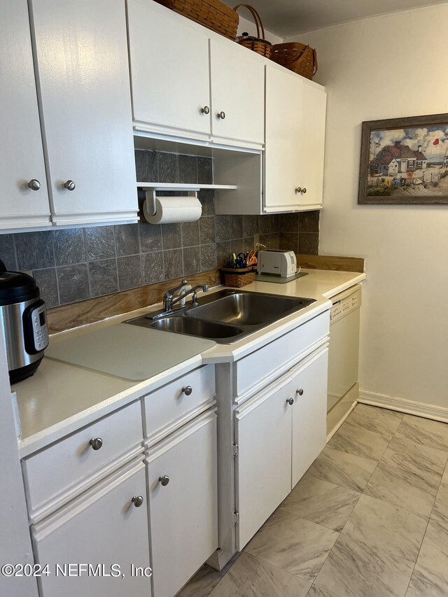 kitchen featuring decorative backsplash, white cabinets, white dishwasher, and light tile patterned floors