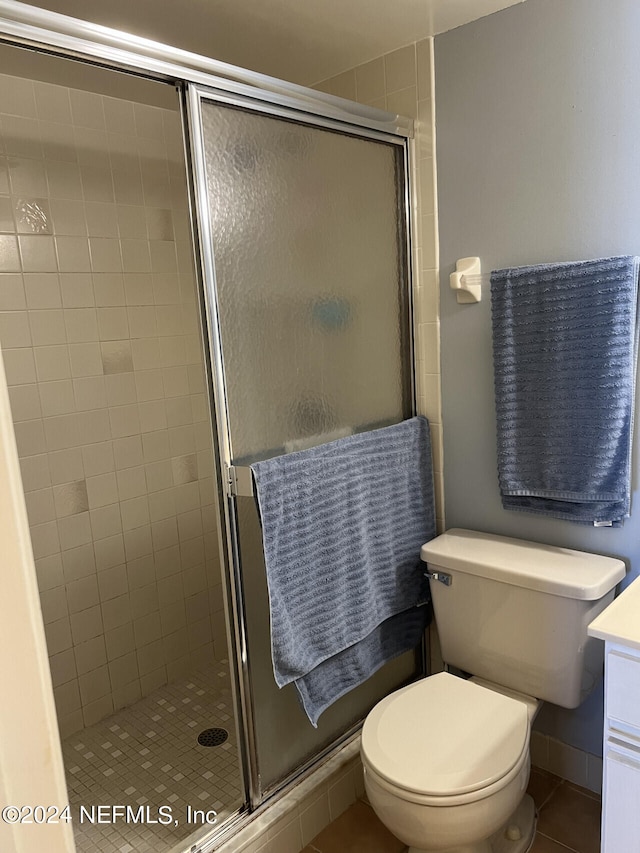 bathroom featuring an enclosed shower, vanity, and toilet