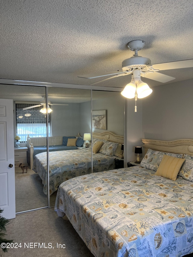 carpeted bedroom with ceiling fan, a textured ceiling, and a closet