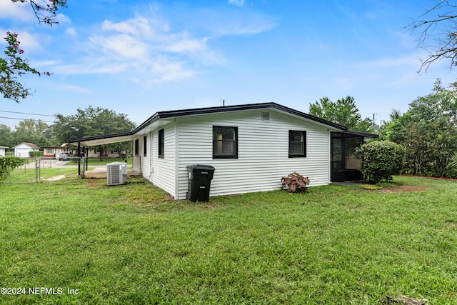 view of side of home with a lawn and central air condition unit