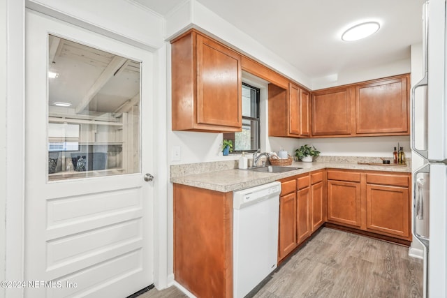 kitchen featuring white appliances, sink, and light hardwood / wood-style flooring