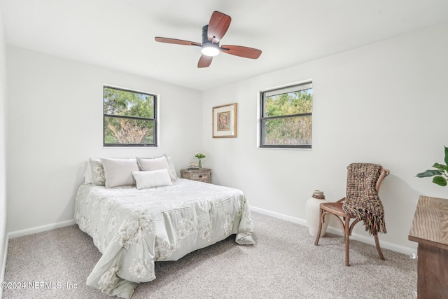 carpeted bedroom featuring multiple windows and ceiling fan