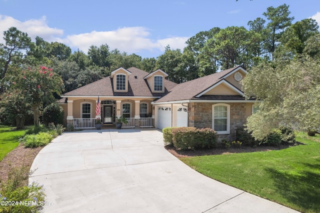 view of front facade featuring a garage, a front yard, and covered porch