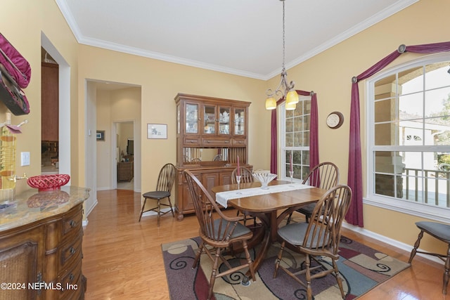 dining room with ornamental molding, baseboards, and light wood finished floors