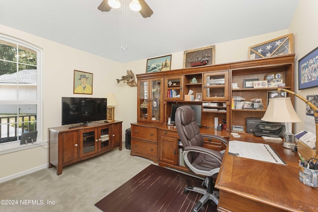 office area with baseboards, a ceiling fan, and light colored carpet