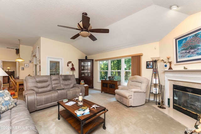 living area featuring ceiling fan, a textured ceiling, light colored carpet, a premium fireplace, and vaulted ceiling