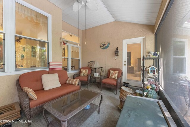 carpeted living room featuring ceiling fan and vaulted ceiling