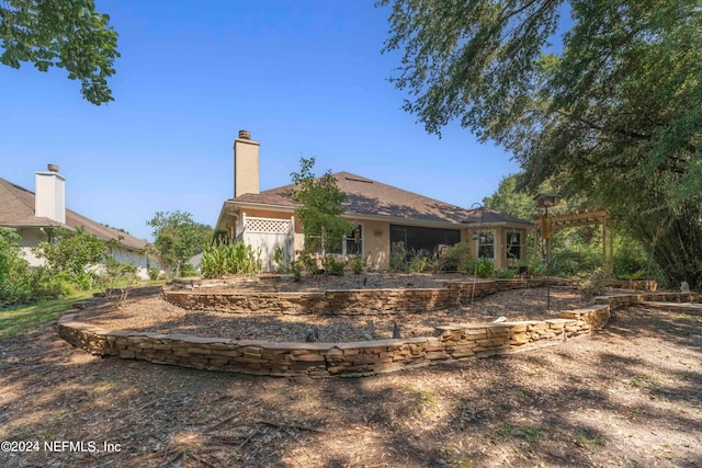 view of front facade with a chimney and a pergola