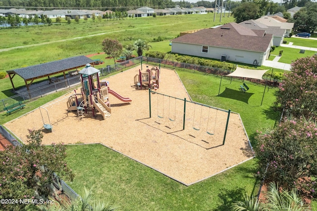 view of property's community with a playground and a yard