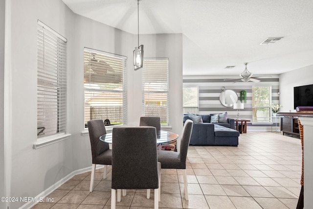 dining room featuring a textured ceiling, ceiling fan, a healthy amount of sunlight, and light tile patterned flooring