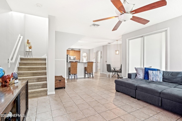 tiled living room featuring ceiling fan