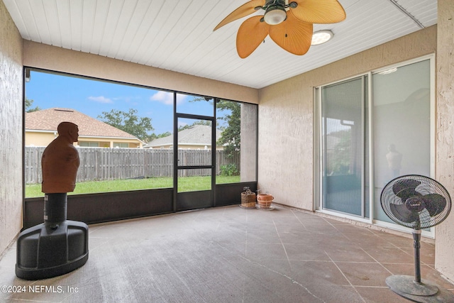 unfurnished sunroom featuring a wealth of natural light and ceiling fan