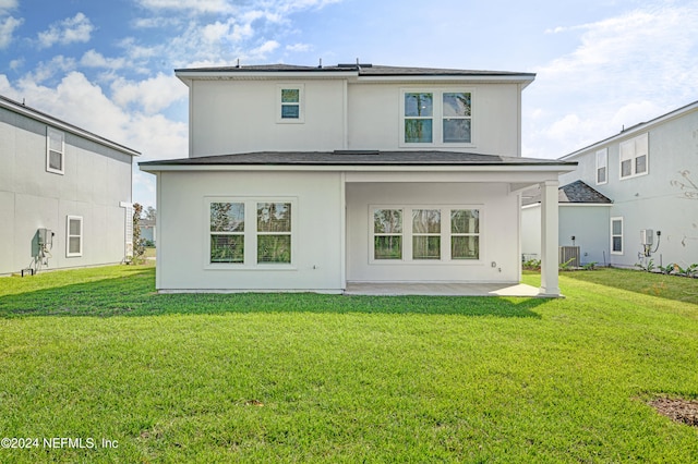 rear view of house featuring a patio area and a lawn