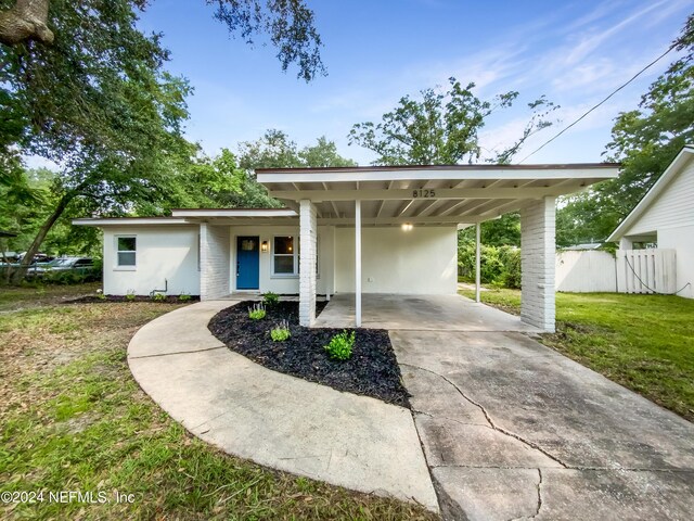 view of front of property with a front yard and a carport