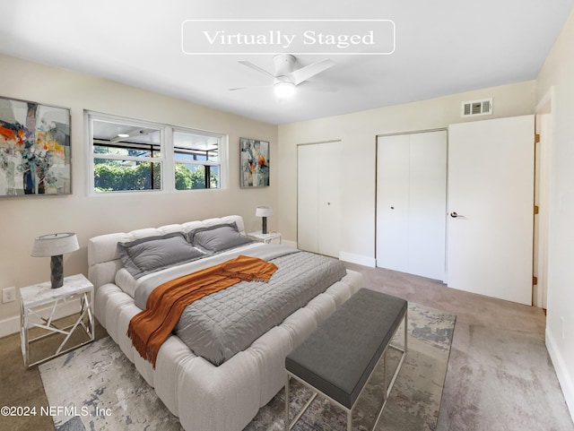 bedroom featuring ceiling fan, two closets, and carpet floors