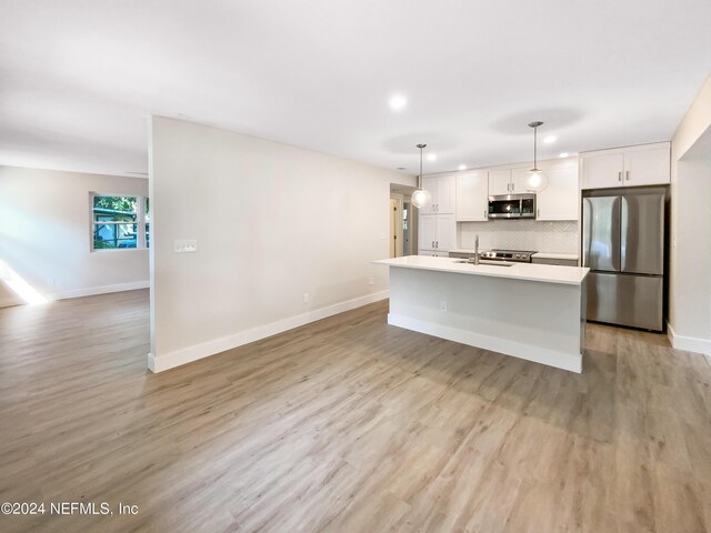 kitchen with light hardwood / wood-style flooring, a center island with sink, stainless steel appliances, and backsplash