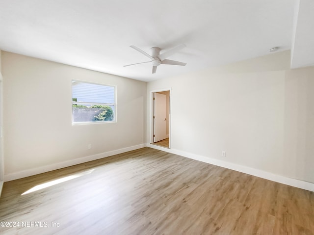 empty room with ceiling fan and light hardwood / wood-style floors