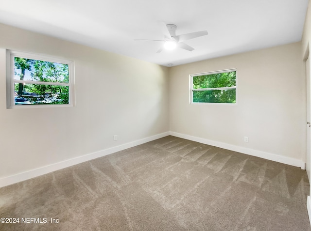 spare room with ceiling fan and carpet